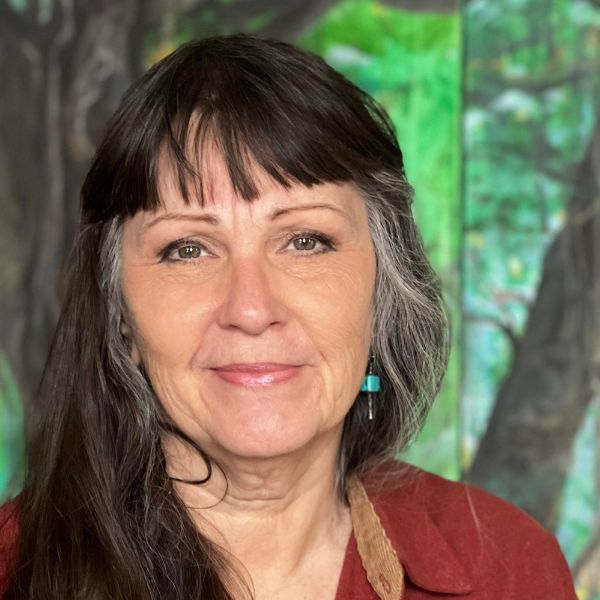 Claire Purgus Pavlik looking at the camera with a green outdoorsy background