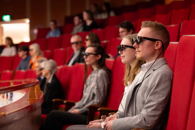 Image of people with glasses in a theater