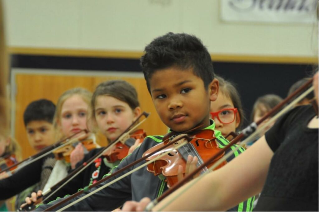 Image of kids playing violin attentively