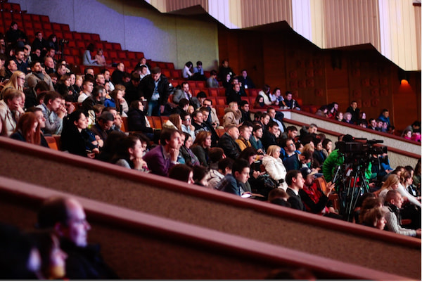 An audience watching a performance from the balcony